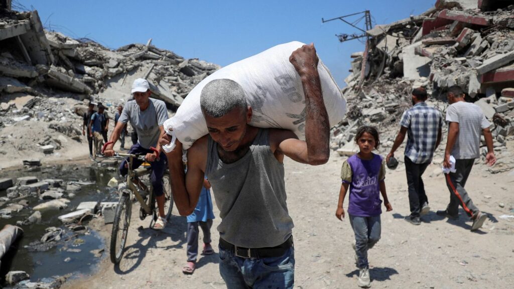 A Palestinian man in Beit Lahia carries aid that entered Gaza through Israel. Pic: Reuters
